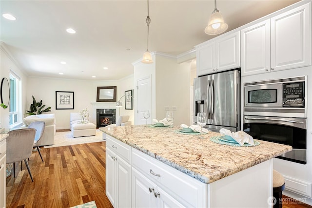 17445 NE 28th St, Redmond, WA 98052 - kitchen with appliances with stainless steel finishes, ornamental molding, light wood finished floors, a kitchen island, and white cabinetry