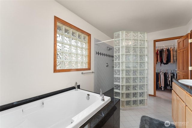 582 Lower Daniels Dr, East Wenatchee, WA 98802 - bathroom with vanity, tile patterned flooring, a garden tub, walk in shower, and a walk in closet