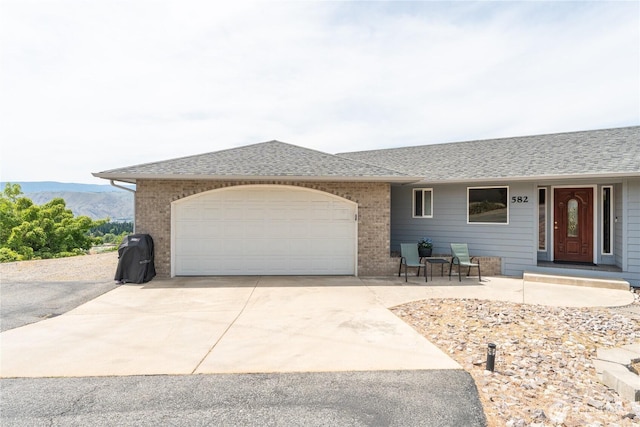582 Lower Daniels Dr, East Wenatchee, WA 98802 - ranch-style house featuring brick siding, driveway, a shingled roof, an attached garage, and a mountain view