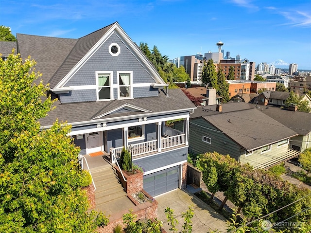 1012 2nd Ave W, Seattle, WA 98119 - view of front facade with a shingled roof, concrete driveway, and an attached garage