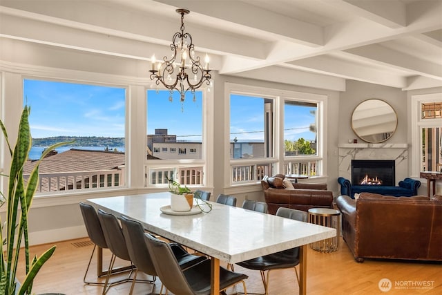 1012 2nd Ave W, Seattle, WA 98119 - dining area with a fireplace, light wood finished floors, a chandelier, beamed ceiling, and a water view