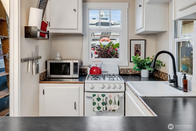 2143 N Northlake Way Unit 11, Seattle, WA 98103 - kitchen with stainless steel microwave, white range with gas cooktop, and white cabinets