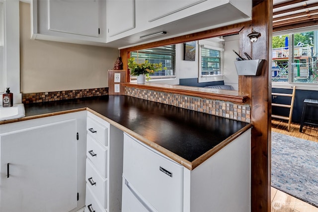 2143 N Northlake Way Unit 11, Seattle, WA 98103 - kitchen featuring dark countertops, white cabinets, wood finished floors, and backsplash
