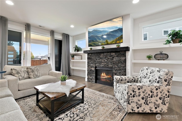 3359 Terry Ln, Enumclaw, WA 98022 - living area featuring healthy amount of natural light, a stone fireplace, wood finished floors, and recessed lighting