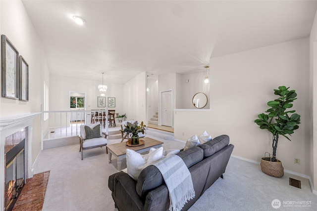 7969 W Golf Course Dr, Birch Bay, WA 98230 - carpeted living room with a tile fireplace, stairs, and a chandelier