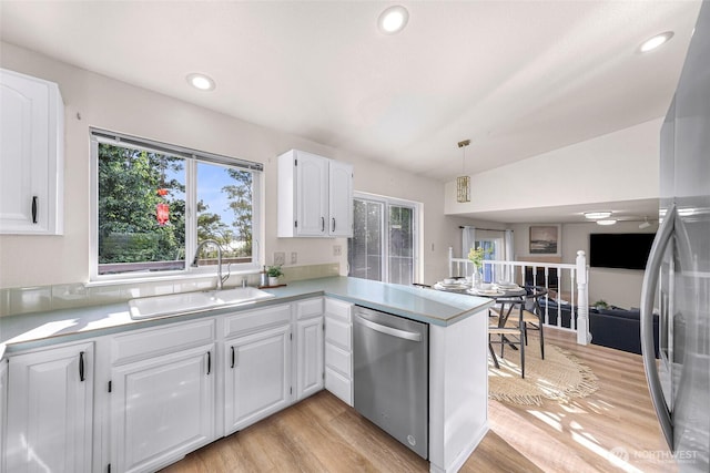7969 W Golf Course Dr, Birch Bay, WA 98230 - kitchen with appliances with stainless steel finishes, plenty of natural light, white cabinetry, a peninsula, and vaulted ceiling