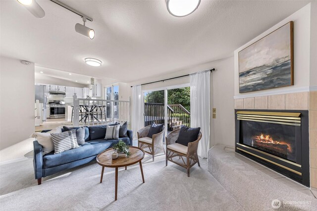7969 W Golf Course Dr, Birch Bay, WA 98230 - living area with light carpet, a tiled fireplace, and track lighting