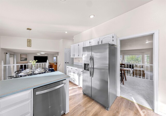 7969 W Golf Course Dr, Birch Bay, WA 98230 - kitchen featuring stainless steel appliances, white cabinetry, light wood-type flooring, decorative light fixtures, and recessed lighting
