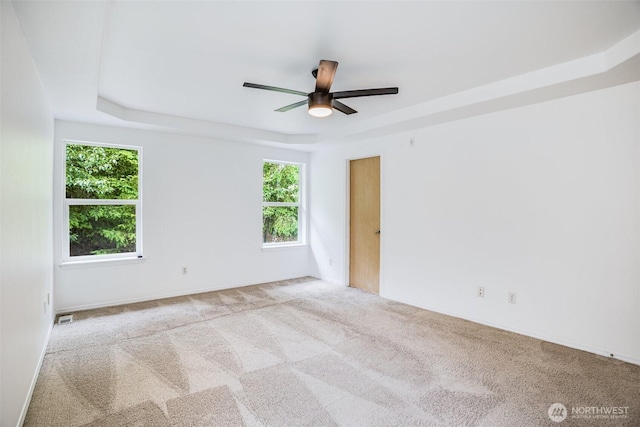 14926 Woodland Ave E, Puyallup, WA 98375 - carpeted empty room featuring plenty of natural light, ceiling fan, and a raised ceiling