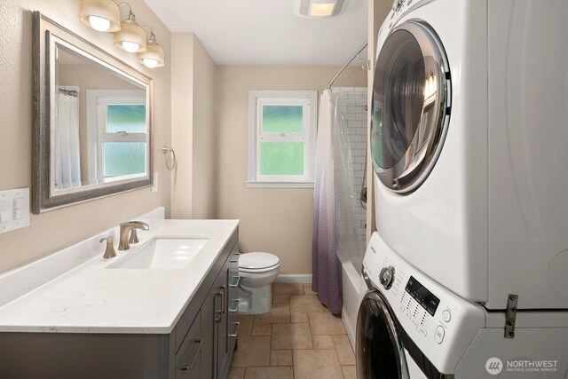14226 44th St NE, Lake Stevens, WA 98258 - bathroom with stacked washer and clothes dryer, vanity, stone tile floors, and shower / bath combo with shower curtain
