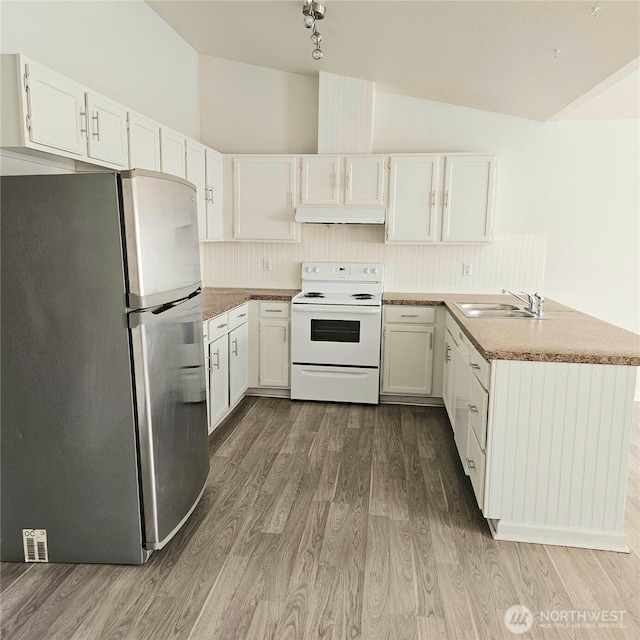 24827 36th Ave E, Spanaway, WA 98387 - kitchen with freestanding refrigerator, white electric stove, under cabinet range hood, wood finished floors, and a peninsula