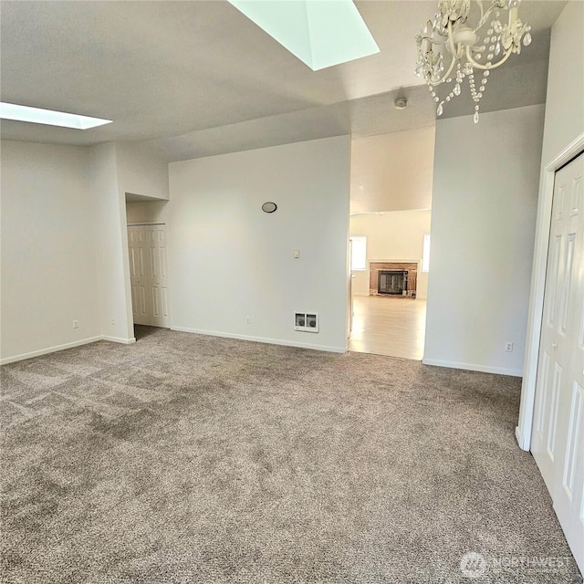 24827 36th Ave E, Spanaway, WA 98387 - unfurnished living room featuring a skylight, carpet flooring, and a chandelier