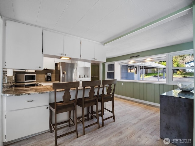 7217 20th Ave SE, Lacey, WA 98503 - kitchen featuring freestanding refrigerator, white microwave, light wood-style floors, white cabinetry, and decorative backsplash