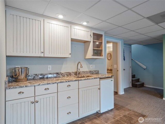 7217 20th Ave SE, Lacey, WA 98503 - kitchen with dishwasher, dark carpet, dark tile patterned flooring, glass insert cabinets, and light stone countertops
