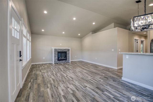 213 N Wynoochee Dr SW, Ocean Shores, WA 98569 - unfurnished living room with dark wood-style flooring, a chandelier, a fireplace, vaulted ceiling, and recessed lighting