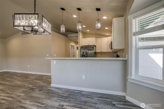 213 N Wynoochee Dr SW, Ocean Shores, WA 98569 - kitchen with refrigerator with ice dispenser, a chandelier, vaulted ceiling, baseboards, and white cabinets