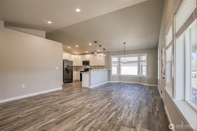 213 N Wynoochee Dr SW, Ocean Shores, WA 98569 - unfurnished living room with dark wood-style flooring, baseboards, recessed lighting, and vaulted ceiling