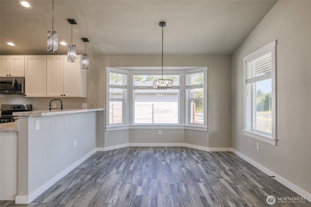 213 N Wynoochee Dr SW, Ocean Shores, WA 98569 - kitchen with appliances with stainless steel finishes, a chandelier, dark wood-type flooring, white cabinetry, and baseboards