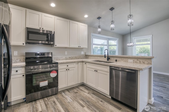 213 N Wynoochee Dr SW, Ocean Shores, WA 98569 - kitchen with appliances with stainless steel finishes, a sink, a peninsula, white cabinetry, and light wood finished floors