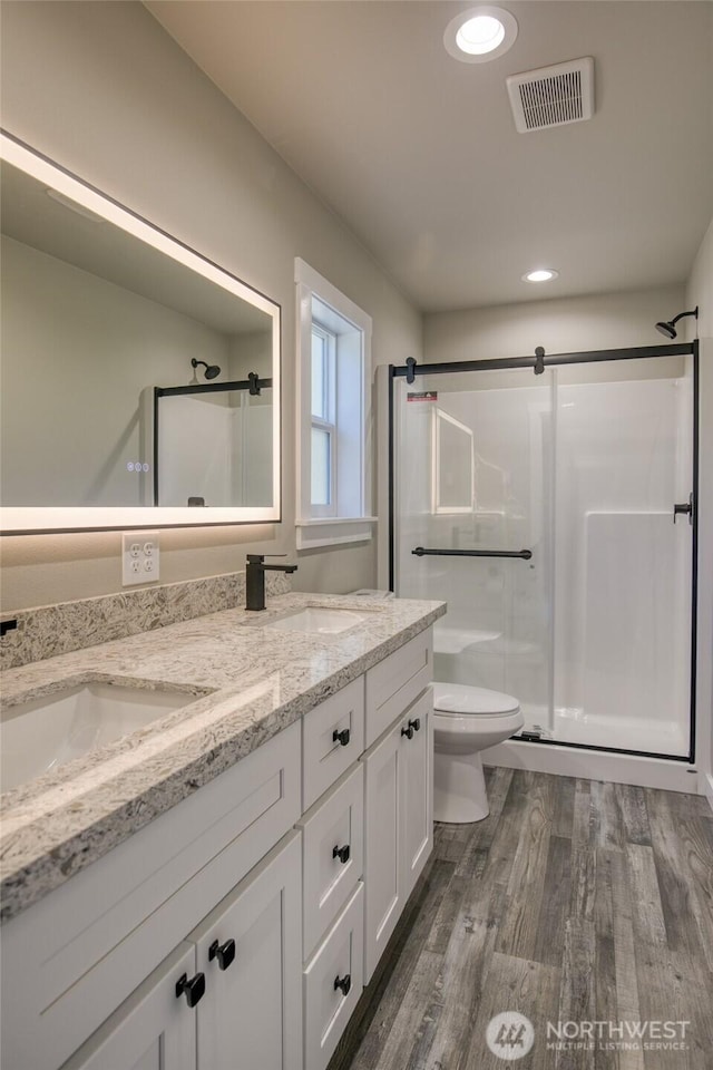 213 N Wynoochee Dr SW, Ocean Shores, WA 98569 - full bathroom with a stall shower, double vanity, wood finished floors, toilet, and recessed lighting