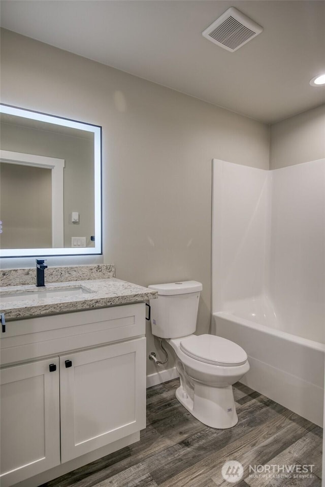 213 N Wynoochee Dr SW, Ocean Shores, WA 98569 - bathroom featuring toilet, vanity, wood finished floors, bathtub / shower combination, and recessed lighting