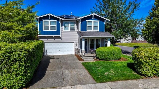 15204 48th Ave SE, Everett, WA 98208 - view of front facade with driveway, solar panels, a garage, covered porch, and stone siding