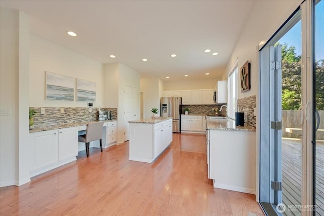 15204 48th Ave SE, Everett, WA 98208 - kitchen featuring stainless steel refrigerator with ice dispenser, decorative backsplash, a kitchen island, white cabinets, and light wood-type flooring