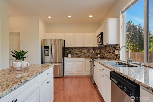 15204 48th Ave SE, Everett, WA 98208 - kitchen with stainless steel appliances, white cabinets, light wood-style floors, light stone counters, and recessed lighting