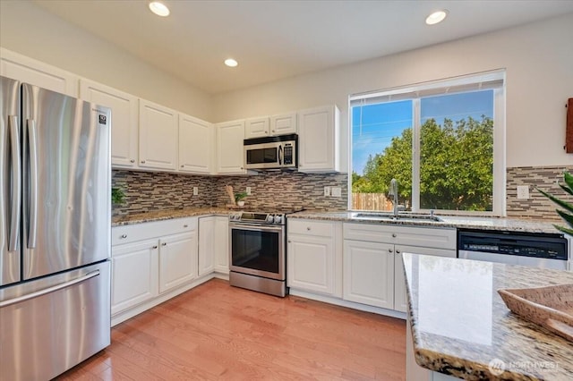 15204 48th Ave SE, Everett, WA 98208 - kitchen with stainless steel appliances, white cabinets, light wood-style flooring, and recessed lighting