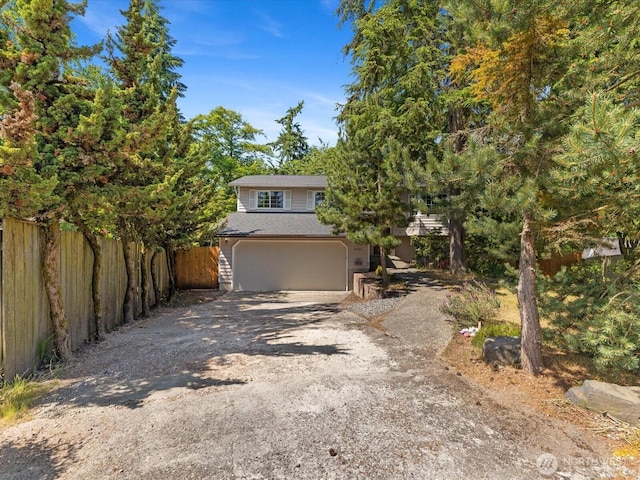 10122 50th Pl W, Mukilteo, WA 98275 - view of property hidden behind natural elements featuring concrete driveway, an attached garage, and a shingled roof