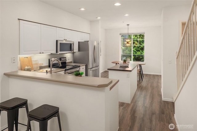 16125 Juanita Woodinville Way NE Unit 1807, Bothell, WA 98011 - kitchen with stainless steel appliances, a peninsula, a center island, dark wood finished floors, and recessed lighting