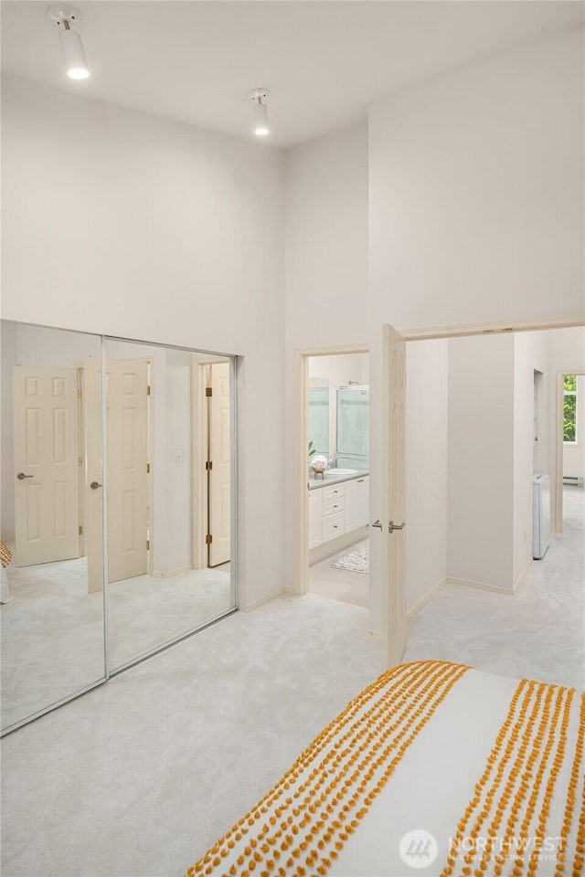 16125 Juanita Woodinville Way NE Unit 1807, Bothell, WA 98011 - unfurnished bedroom featuring a towering ceiling, carpet floors, and ensuite bathroom