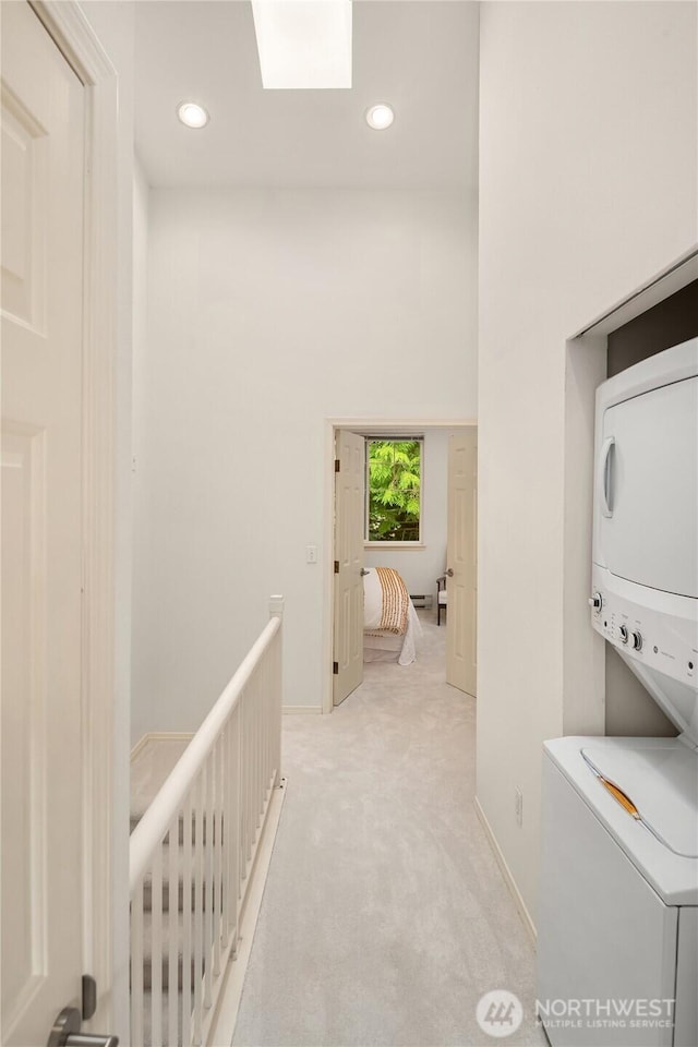 16125 Juanita Woodinville Way NE Unit 1807, Bothell, WA 98011 - corridor featuring stacked washer / drying machine, light colored carpet, a skylight, recessed lighting, and an upstairs landing