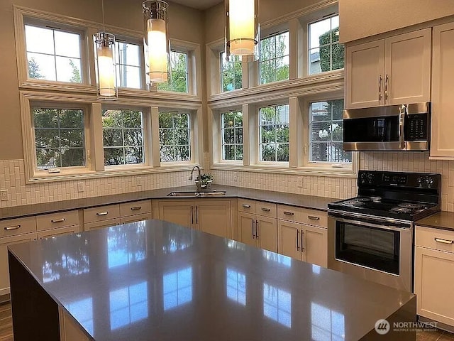 16125 Juanita Woodinville Way NE Unit 1807, Bothell, WA 98011 - kitchen featuring stainless steel appliances, decorative backsplash, decorative light fixtures, and dark countertops