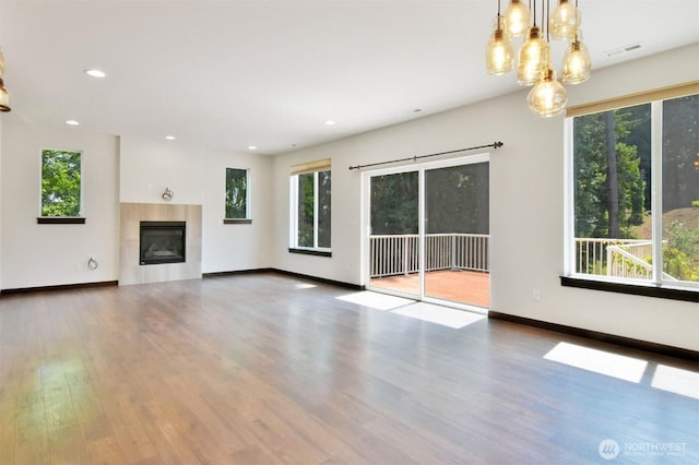 17723 3rd Ave SE, Bothell, WA 98012 - unfurnished living room with plenty of natural light, wood finished floors, a tile fireplace, a chandelier, and recessed lighting