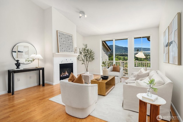 23420 SE Black Nugget Rd Unit E-302, Issaquah, WA 98029 - living area featuring a tile fireplace, wood finished floors, and lofted ceiling