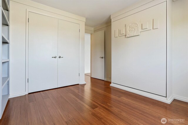 3717 Beach Dr SW Unit 113, Seattle, WA 98116 - unfurnished bedroom with wood finished floors and a closet
