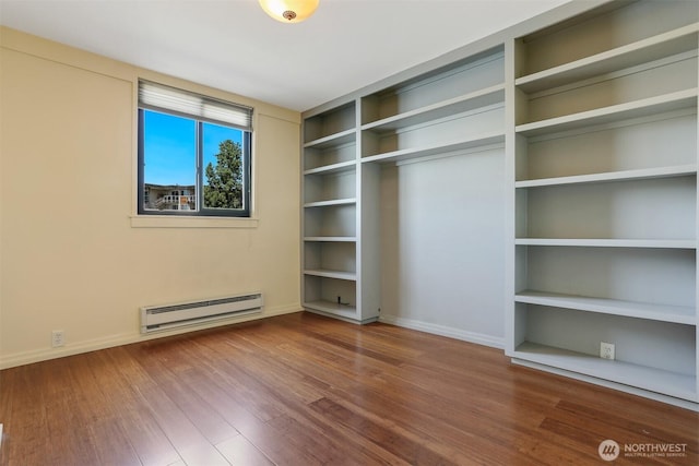 3717 Beach Dr SW Unit 113, Seattle, WA 98116 - unfurnished bedroom with a baseboard heating unit and wood finished floors