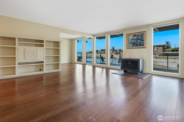 3717 Beach Dr SW Unit 113, Seattle, WA 98116 - unfurnished living room featuring a wood stove and wood finished floors