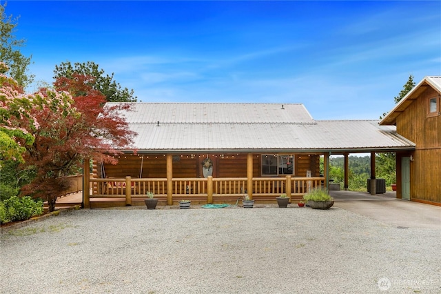 4004 Saje Ln, Sedro Woolley, WA 98284 - log cabin featuring driveway, an attached carport, a porch, and a metal roof