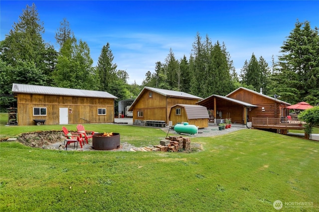 4004 Saje Ln, Sedro Woolley, WA 98284 - view of green lawn with a fire pit, a deck, and a storage shed