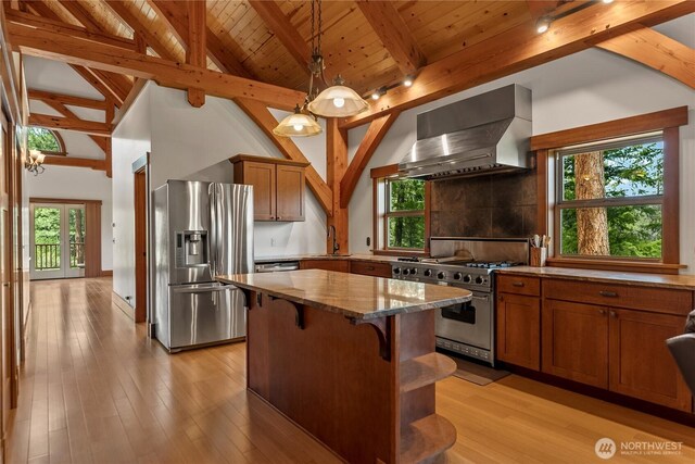 65 Fiddlers Rd, Winthrop, WA 98862 - kitchen with stainless steel appliances, wall chimney exhaust hood, stone counters, brown cabinetry, and a center island