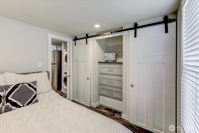 8542 Crescent Bar Rd NW Unit 346, Quincy, WA 98848 - bedroom featuring stacked washer / drying machine, a barn door, freestanding refrigerator, dark wood-style floors, and ensuite bathroom