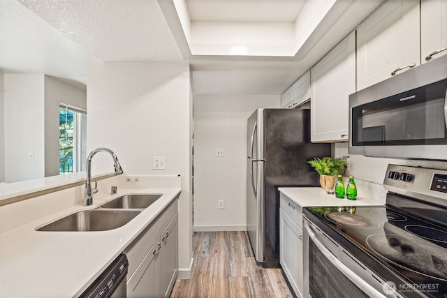 12617 NE 130th Way Unit E201, Kirkland, WA 98034 - kitchen featuring stainless steel appliances, light wood-style floors, light countertops, and white cabinetry