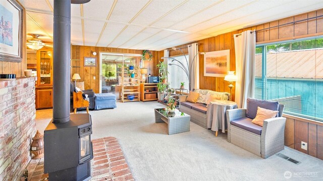 20 NE Wanda Ct, Belfair, WA 98528 - carpeted living area with wooden walls and a wood stove