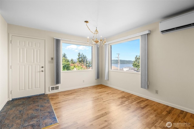 2834 Leeward Way, Bellingham, WA 98226 - unfurnished dining area featuring a chandelier, an AC wall unit, healthy amount of natural light, and wood finished floors