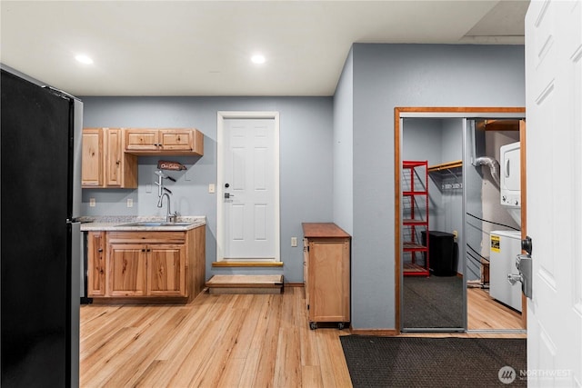 11358 River Bend Dr, Leavenworth, WA 98826 - kitchen featuring stacked washer / dryer, light wood-type flooring, freestanding refrigerator, light countertops, and recessed lighting
