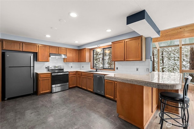 11358 River Bend Dr, Leavenworth, WA 98826 - kitchen with stainless steel appliances, under cabinet range hood, tile countertops, decorative backsplash, and recessed lighting
