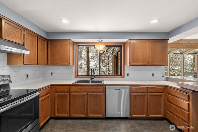 11358 River Bend Dr, Leavenworth, WA 98826 - kitchen featuring stainless steel appliances, under cabinet range hood, light countertops, brown cabinets, and tasteful backsplash