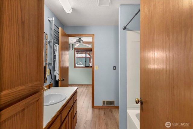 11358 River Bend Dr, Leavenworth, WA 98826 - bathroom featuring vanity, wood finished floors, washtub / shower combination, and a ceiling fan